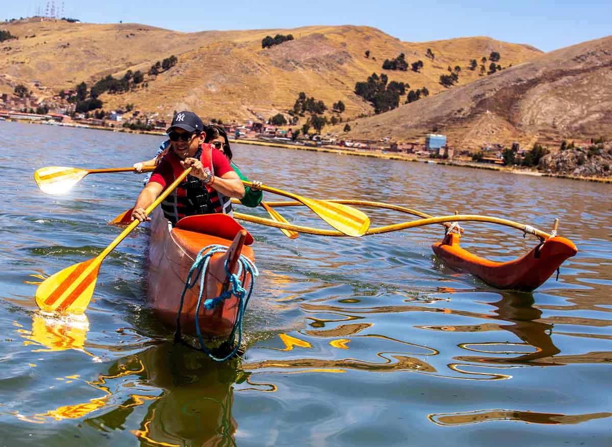 Turistas navegando en canoa polinésica en el Lago Titicac