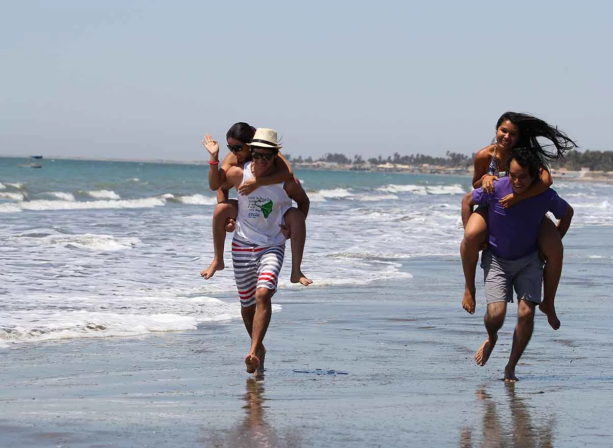 Turistas en la playa Esmeralda del balneario de Colán.