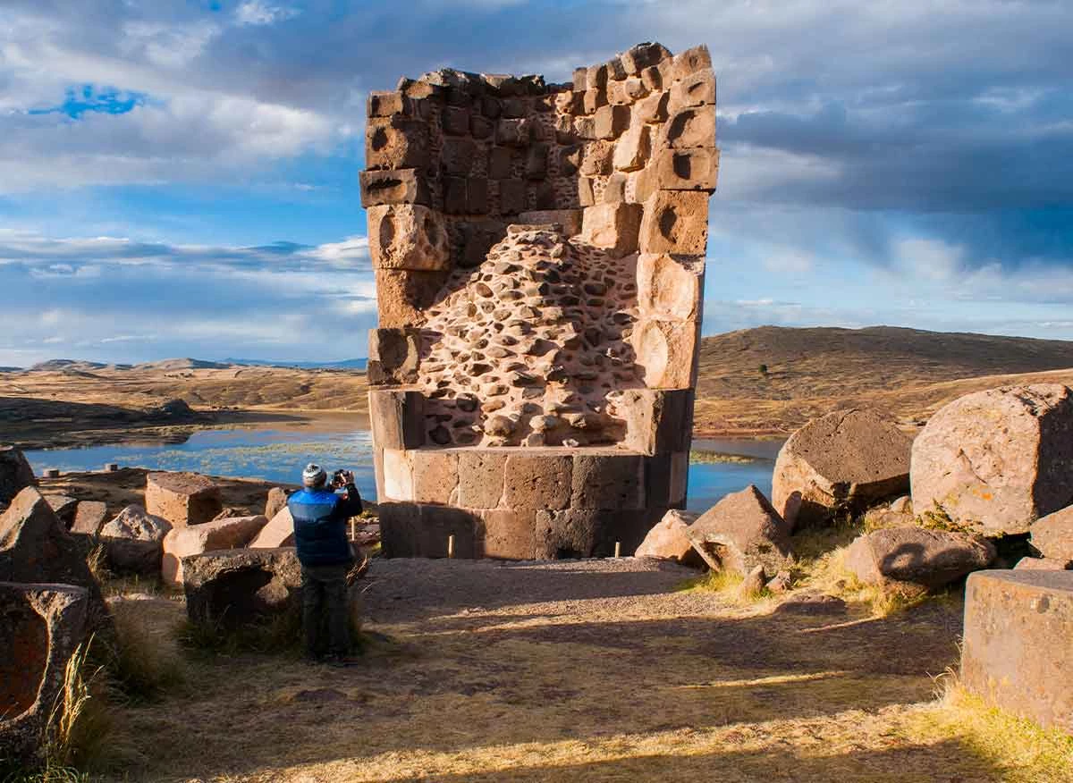 Turista y chullpas en el Complejo Arqueológico de Sillustani.